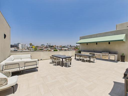 A patio with a table and chairs overlooking a city.