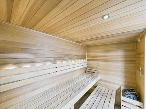 A wooden sauna with benches and a heater.