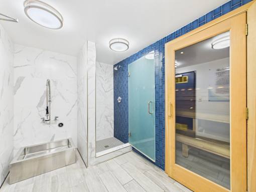 A bathroom with a sink, mirror, and shower.