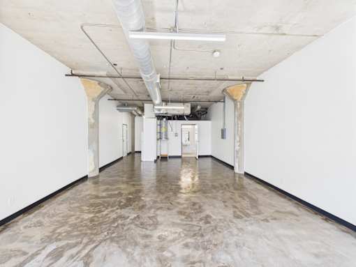 A long hallway with a marble floor and white walls.