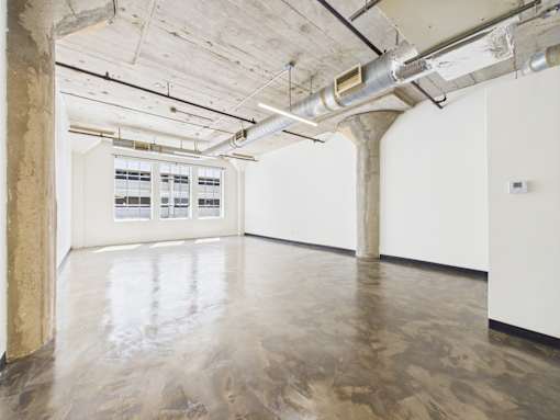 A large empty room with a concrete floor and ceiling.