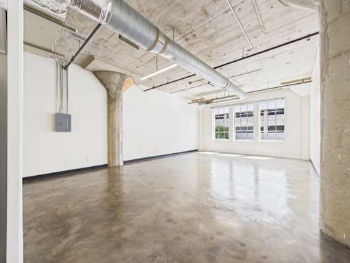 A large empty room with a concrete floor and ceiling.