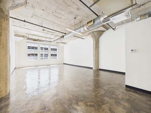 A large empty room with concrete floors and walls.