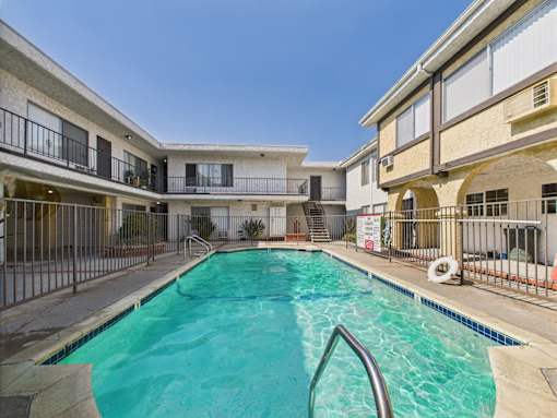 A swimming pool in a residential area surrounded by houses.