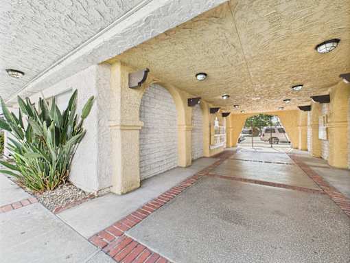 A long corridor with arched columns and a brick border.