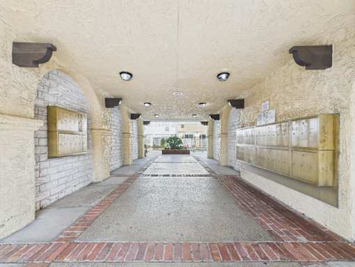 A long corridor with arches and brick flooring.