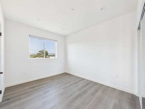 A room with a window and a wooden floor.