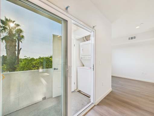 A white refrigerator is in a room with a glass door.