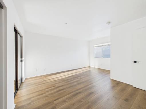 A room with wooden flooring and white walls.