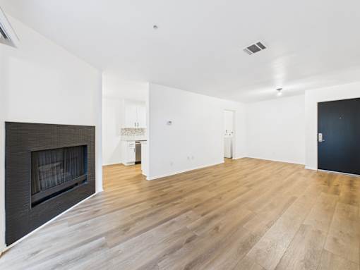 A room with a fireplace and wood flooring.