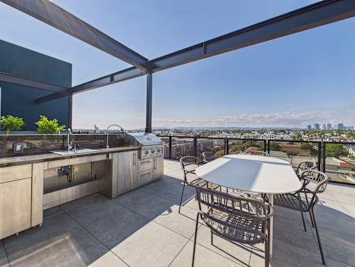 A patio with a table and chairs overlooking a cityscape.