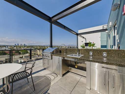 A patio with a table and chairs overlooking a city skyline.