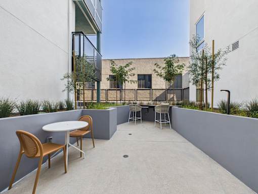 A patio with a table and chairs overlooks a building.