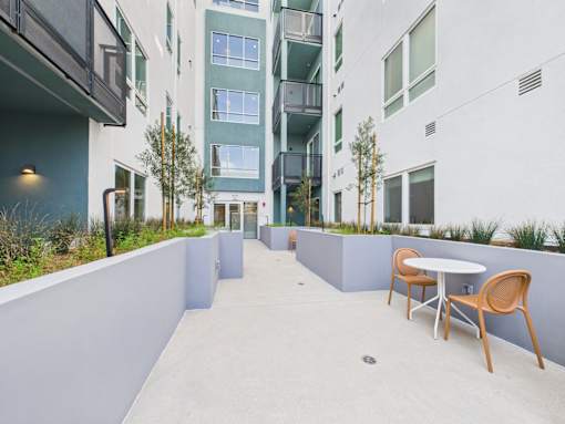 A patio with a table and chairs is surrounded by buildings.