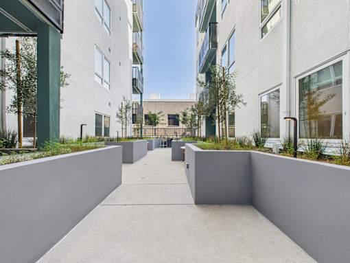 A concrete courtyard is surrounded by white buildings.
