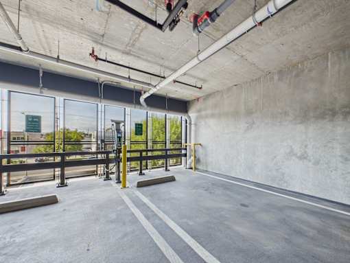 A parking garage with concrete walls and a concrete floor.