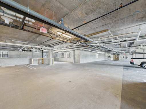 A parking garage with a car parked on the right side.