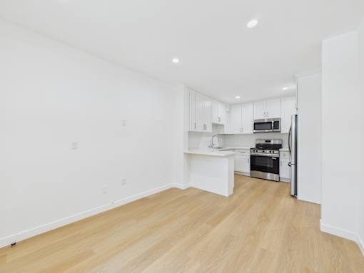 A kitchen with white cabinets and a microwave.
