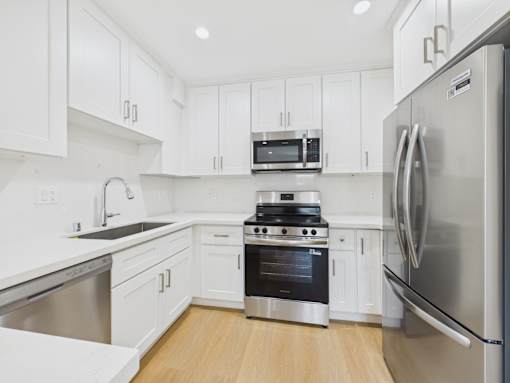 A modern kitchen with stainless steel appliances and white cabinets.