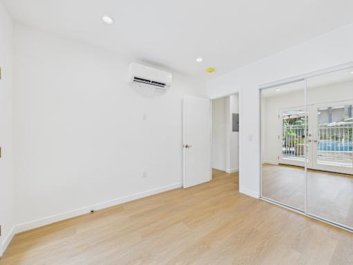 A room with a sliding glass door leading to a balcony.