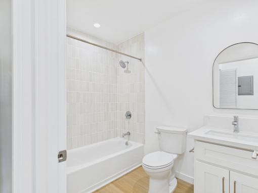 A white bathroom with a toilet, sink, and bathtub.