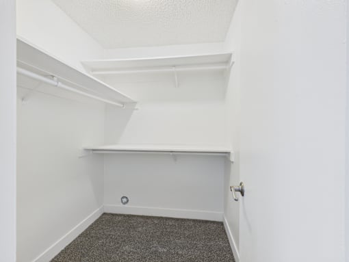 A small, empty room with a carpeted floor and white walls.
