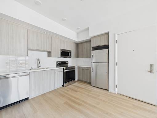 A kitchen with wooden floors and white walls.