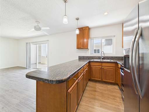A kitchen with wooden cabinets and a black countertop.