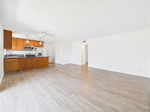 A kitchen with wooden floors and a white ceiling.