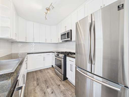 A modern kitchen with a stainless steel refrigerator.