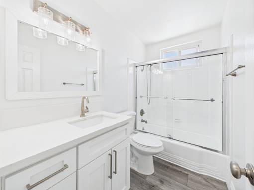 A white bathroom with a walk-in shower and a toilet.