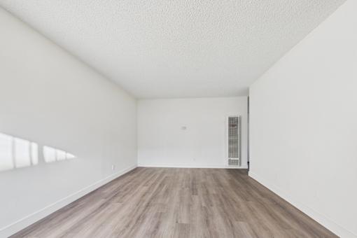 A room with wooden flooring and white walls.