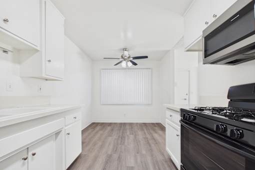 A kitchen with white cabinets and a black stove top oven.
