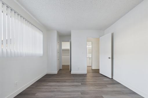 A long hallway with white walls and wood floors.