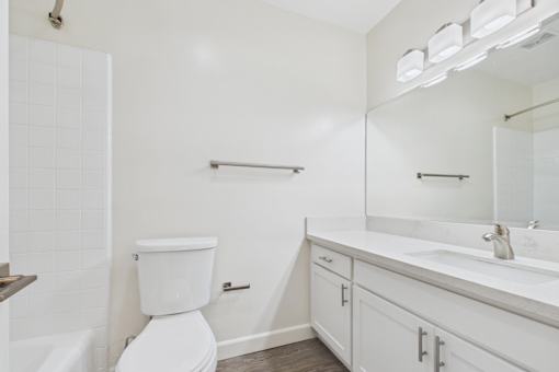 A white toilet sits next to a white sink in a bathroom.