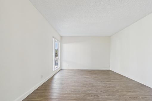 Empty room with wooden floor and white walls.