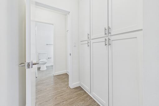 A white bathroom with a toilet and a white door.