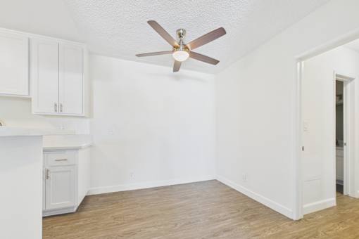 A room with a ceiling fan and wooden flooring.