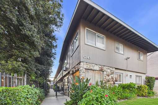 A house numbered 6743 is surrounded by greenery and has a stone pillar at the entrance.