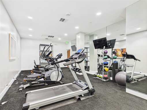 A spacious gym with treadmills, elliptical machines, and other exercise equipment.