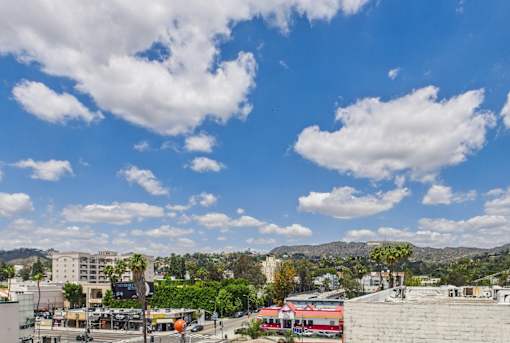 A cityscape with buildings, trees, and a clear sky.