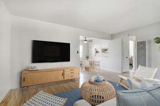 A living room with a television, chairs, and a table.