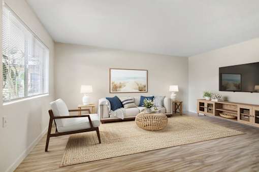A living room with a sofa, chair, and a painting on the wall.