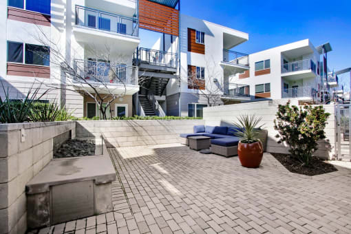 a patio with a couch in front of some apartments