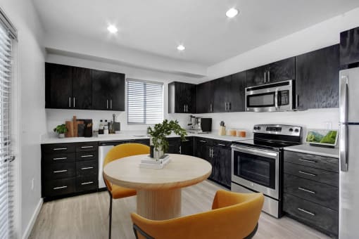 a kitchen with black cabinets and white appliances