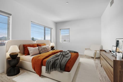 a bedroom with a bed and two windows