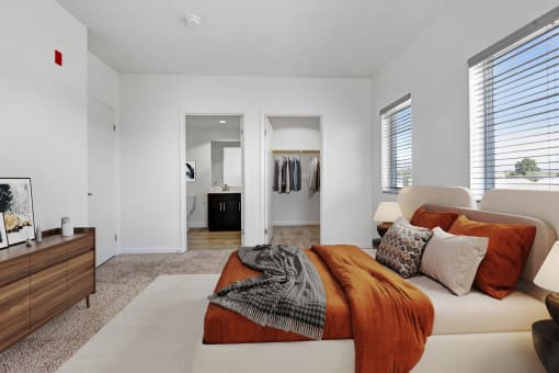 a bedroom with an orange blanket and pillows on a couch