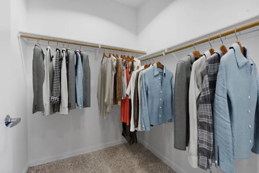 a closet with a rack of clothes and a door