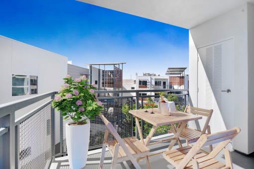 a balcony with a table and chairs and a view of a city