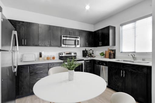 a kitchen with black cabinets and a white table